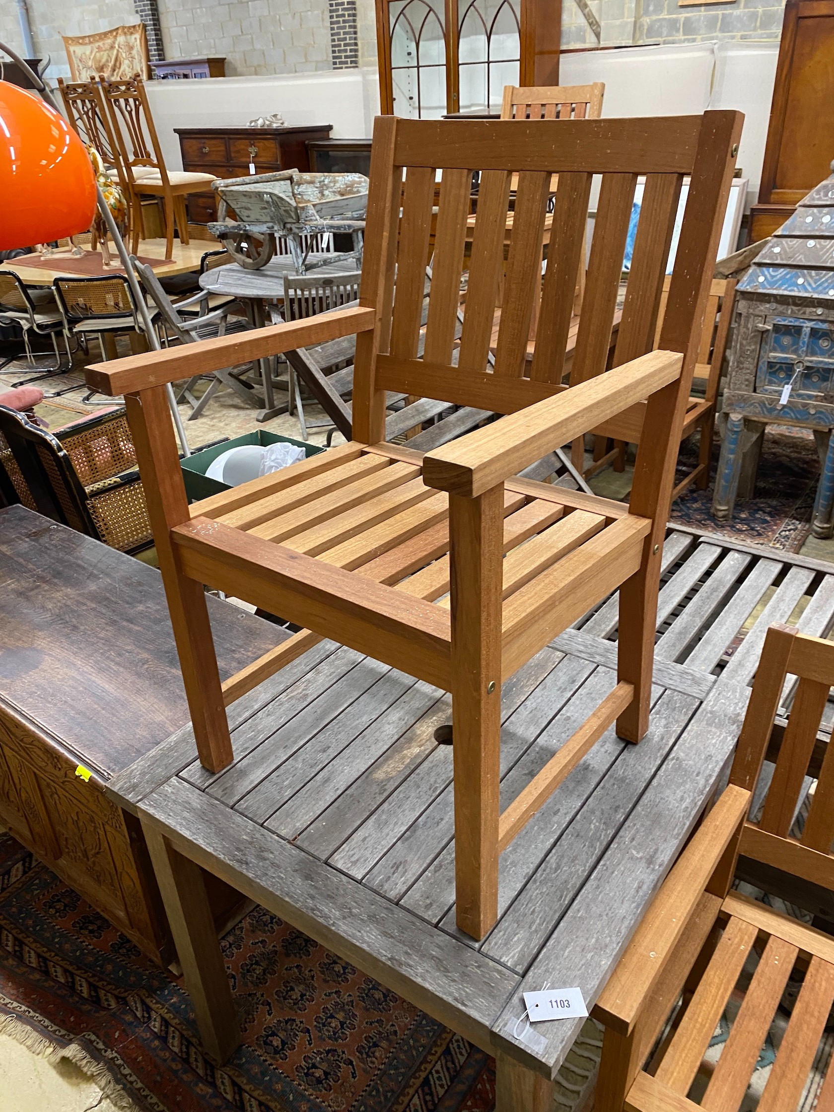 A weathered teak square garden table, width 80cm, height 73cm together with two teak elbow chairs